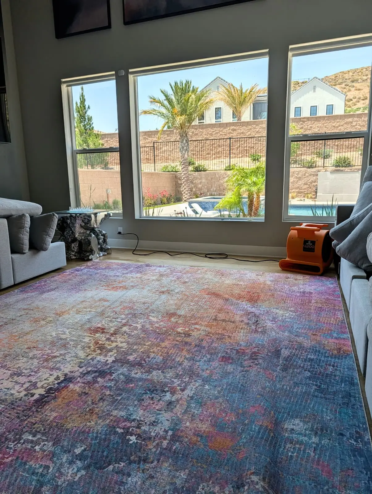 Air mover positioned beside an area rug during drying