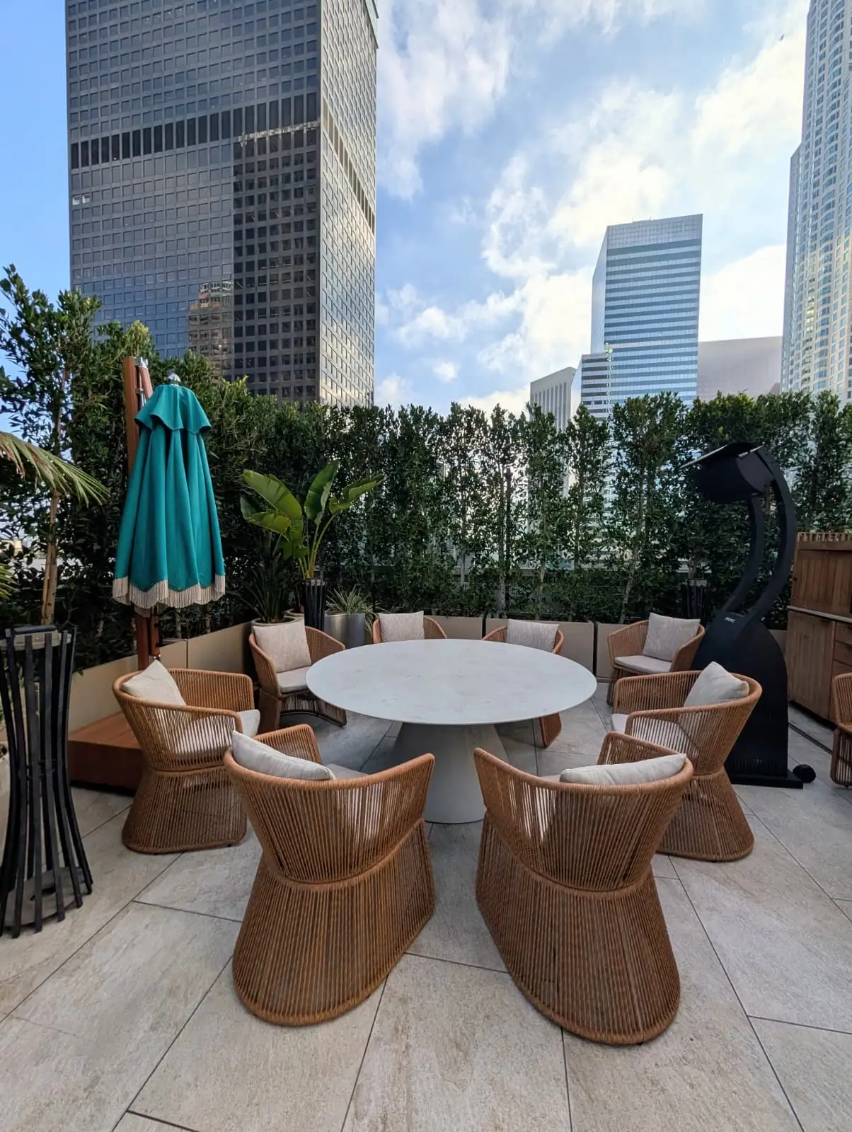 Hotel rooftop dining area with woven chairs and upholstered seat cushions