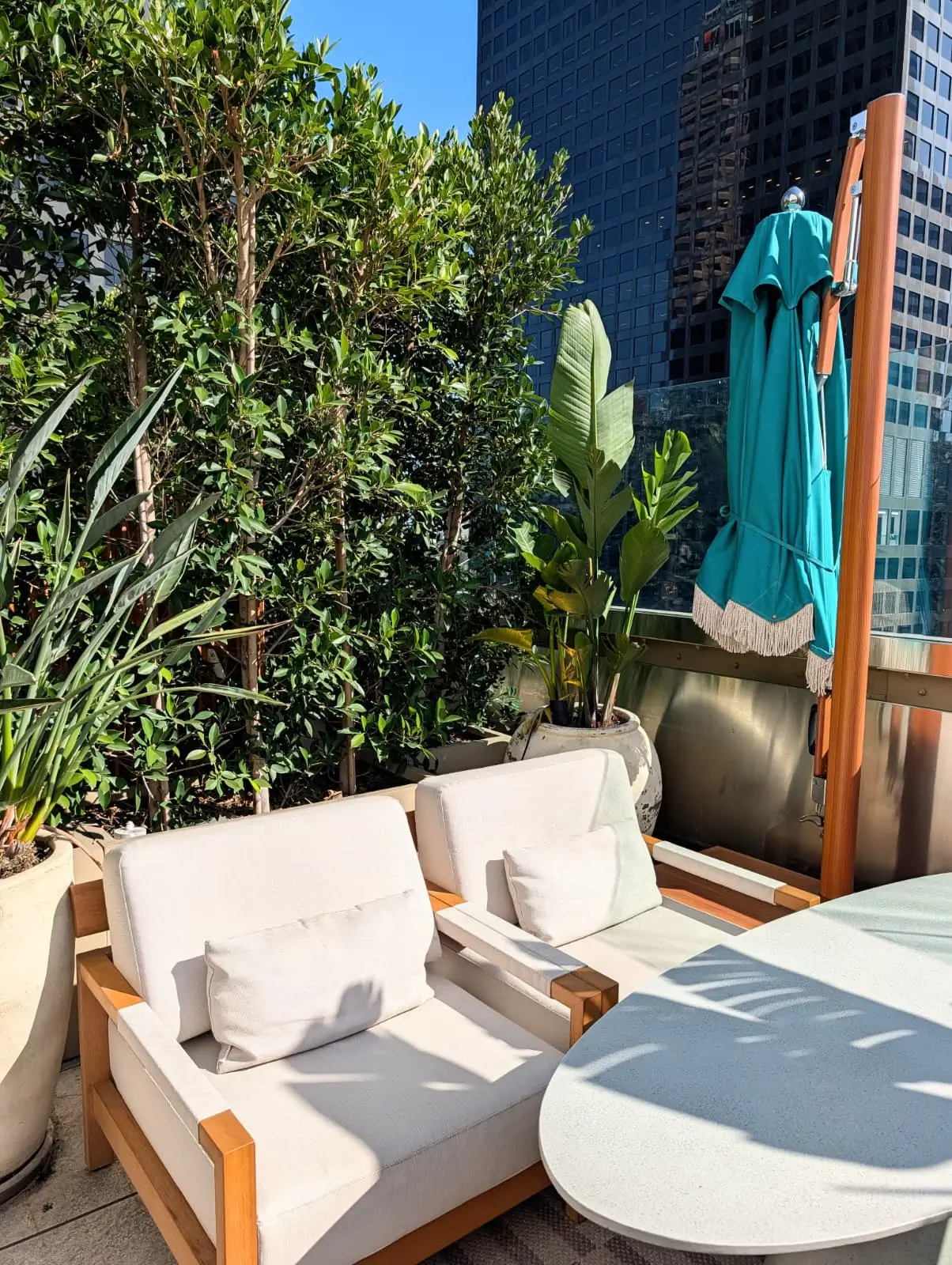 Outdoor hotel lounge chairs with light upholstered cushions beside a table