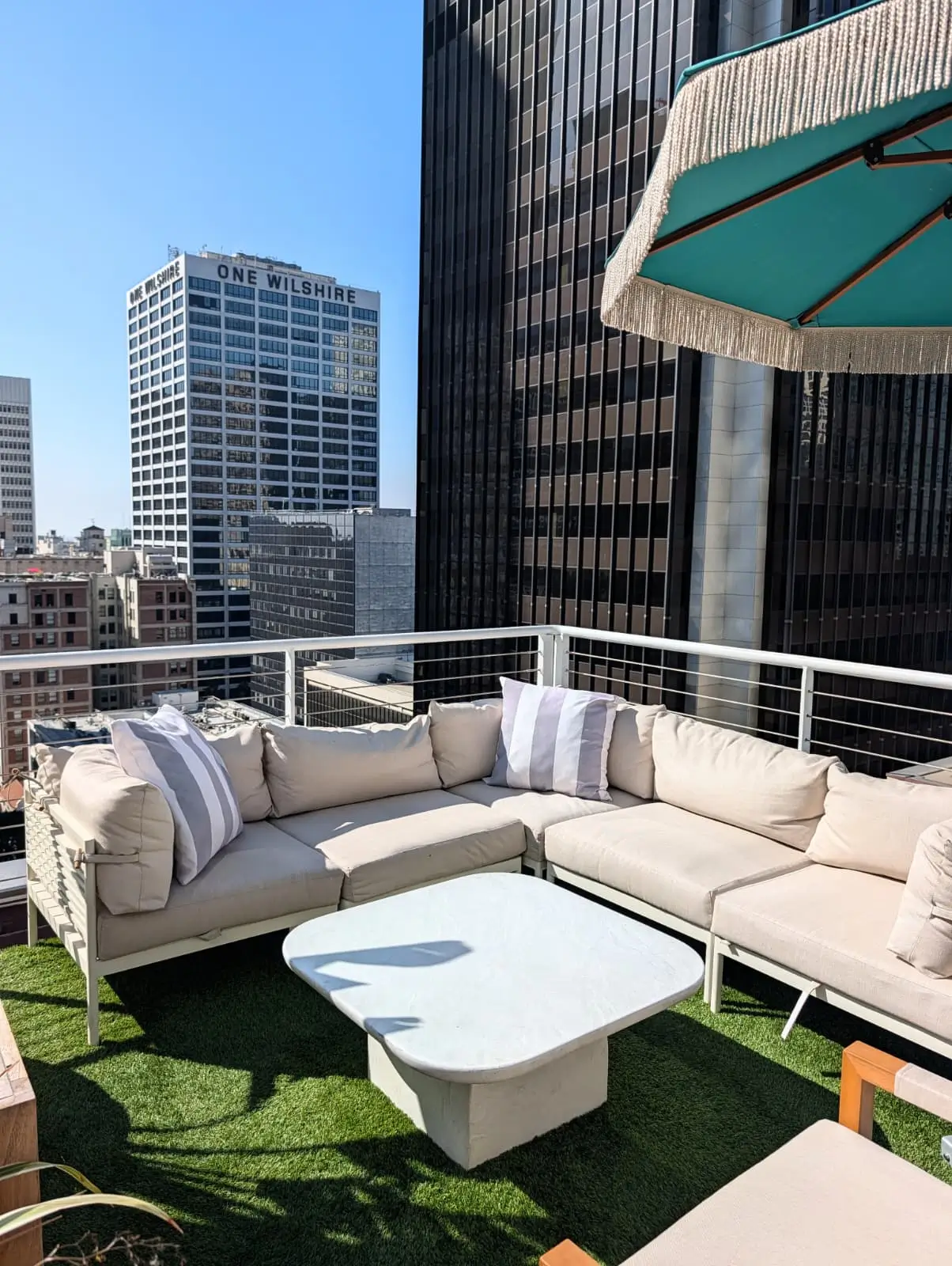 Outdoor sectional sofa with light cushions on a rooftop terrace