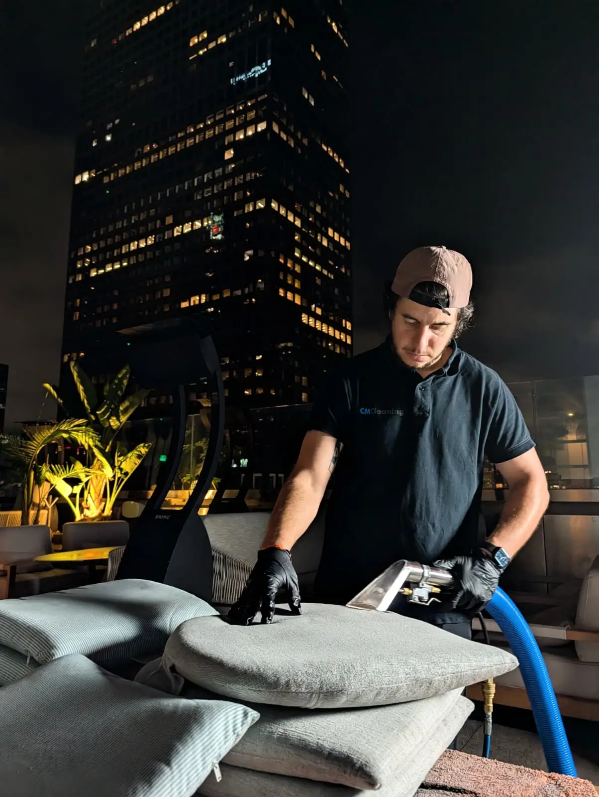 Hotel technician cleaning an upholstered cushion during overnight hotel cleaning