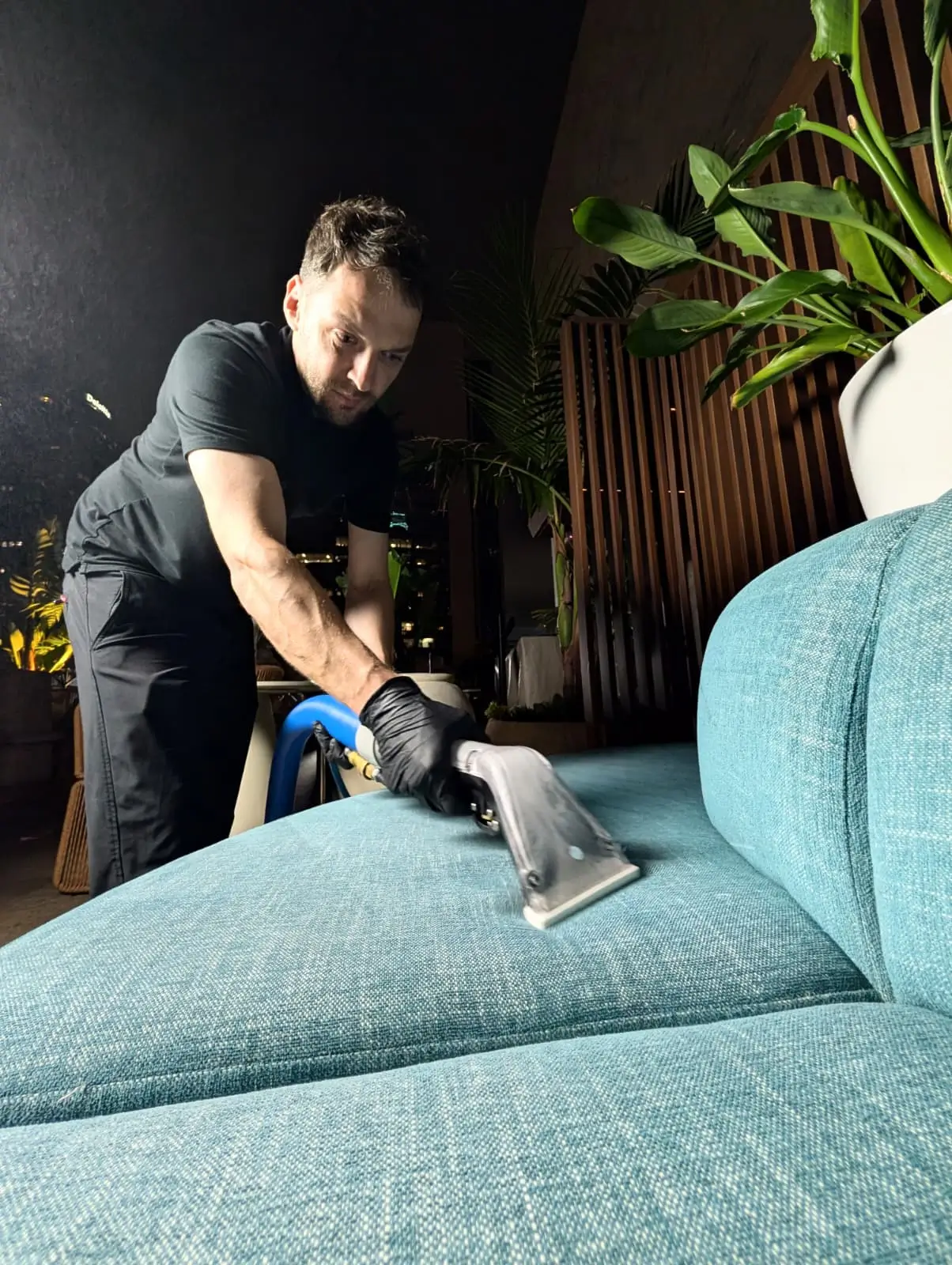 Technician professionally cleaning blue upholstered hotel seating